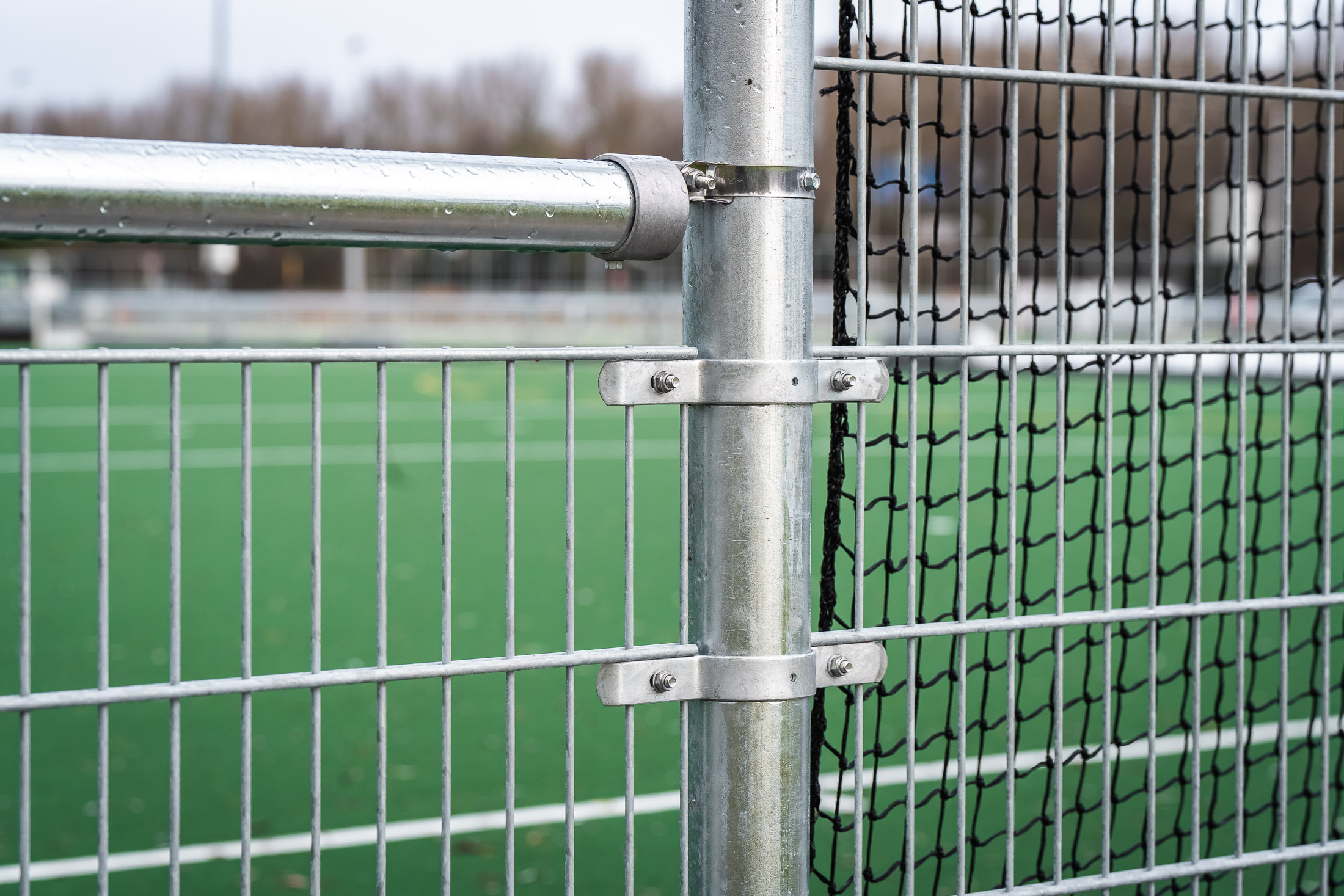 Extended brackets by Buisklem installed on a football field, ensuring structural support for fencing systems.